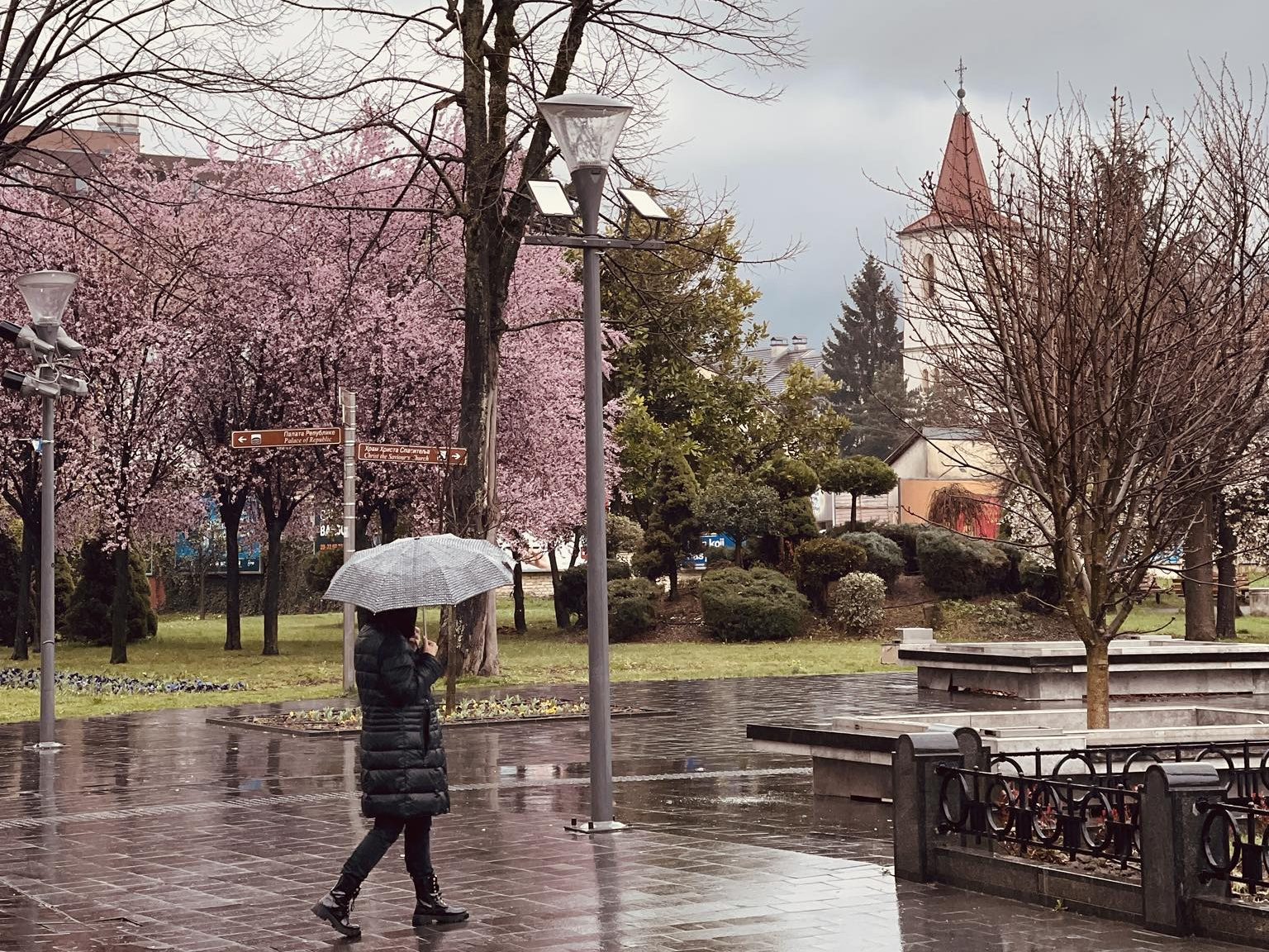 Šetač s kišobranom po kiši u proljetnom gradu