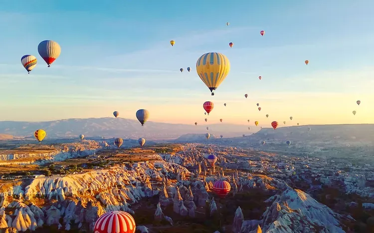 Baloni na topli zrak iznad pejzaža Kapadokije u svitanje
