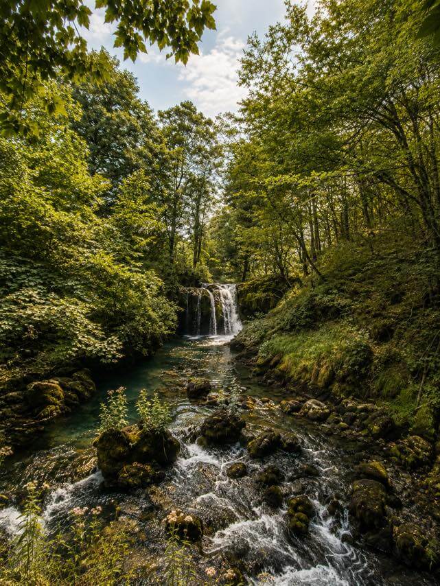 A waterfall in the forest near Sipovo, water over mossy stones