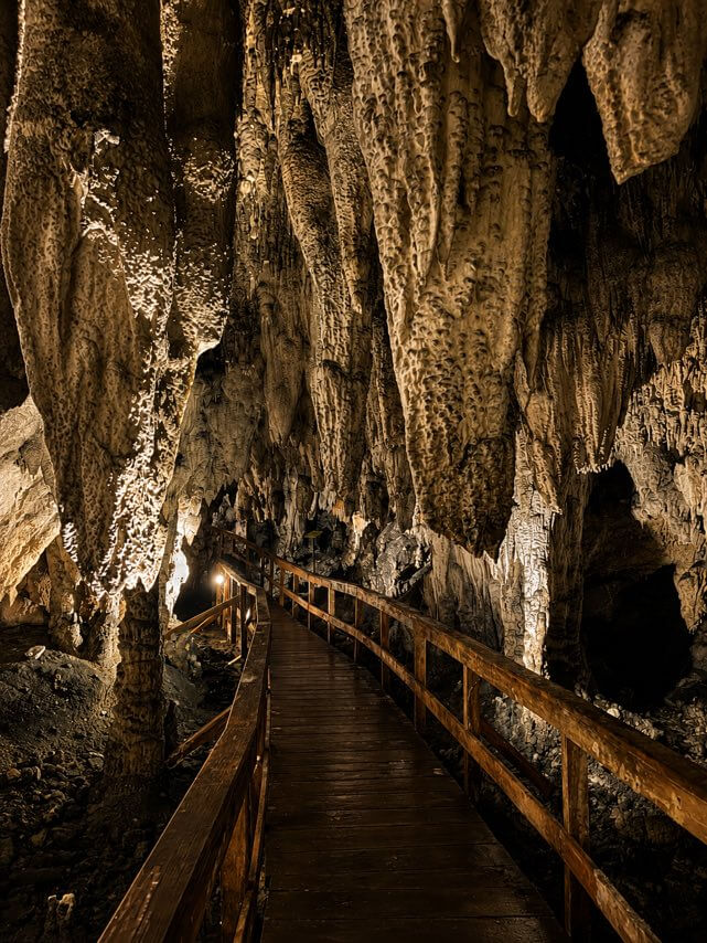 Interior of Vagan Cave with stalactites and a wooden walkway