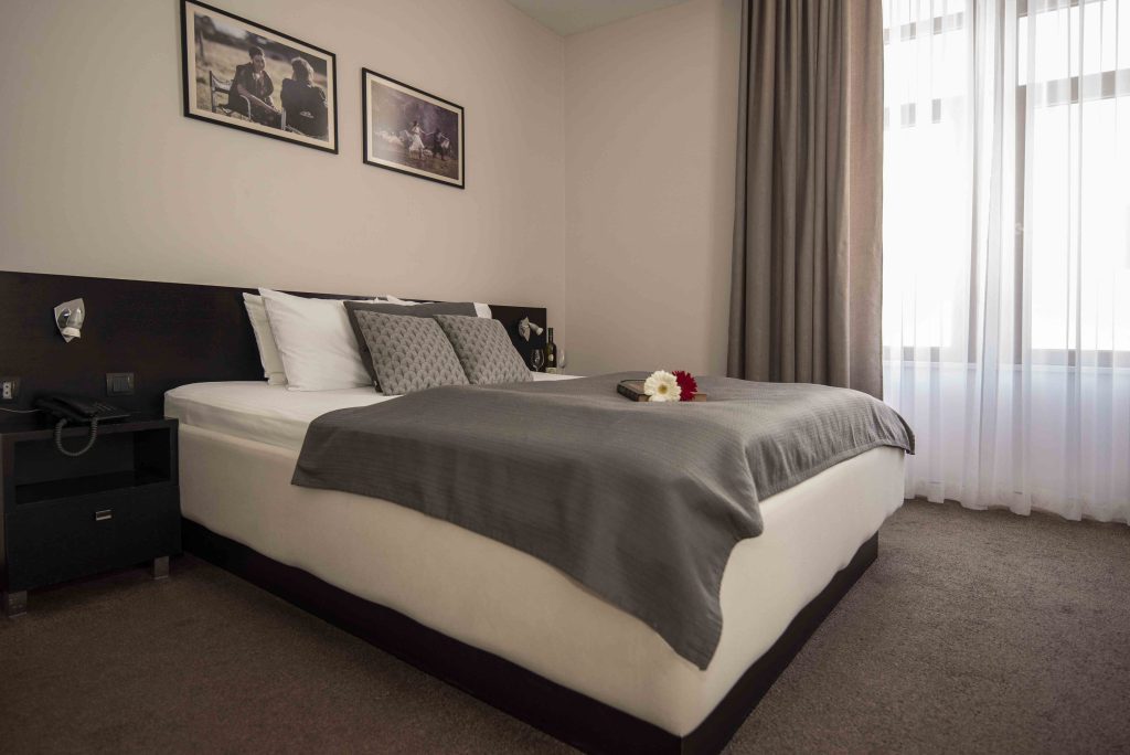 Interior of Monica Bellucci's room at Hotel Platani, with film photographs above the bed
