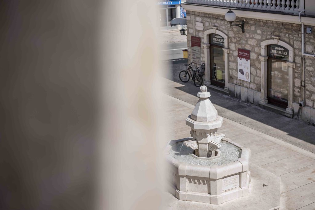 A stone fountain in the square in front of a bookstore in the old part of Trebinje